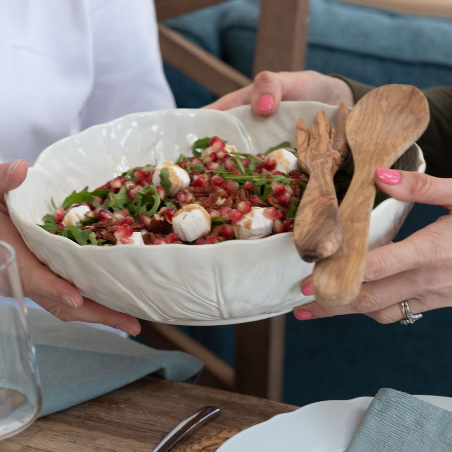 white salad bowl and wooden servers