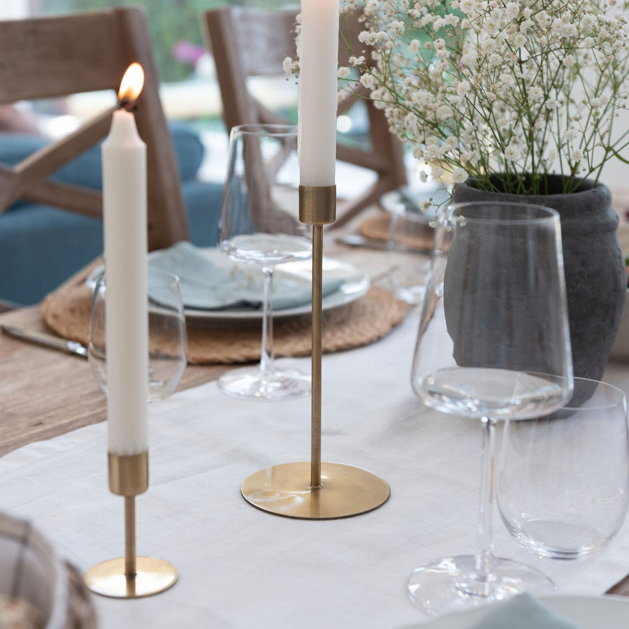 Gold candle holder styled on dining table with white table runner
