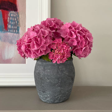 dark grey vase with pink flowers