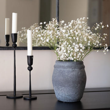 Grey vase with babys breath flowers and black candle holders