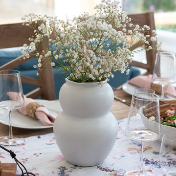 White vase styled on dining table with babys breath