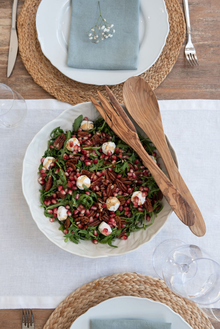 tableware featuring a white salad bowl and wooden serving spoons